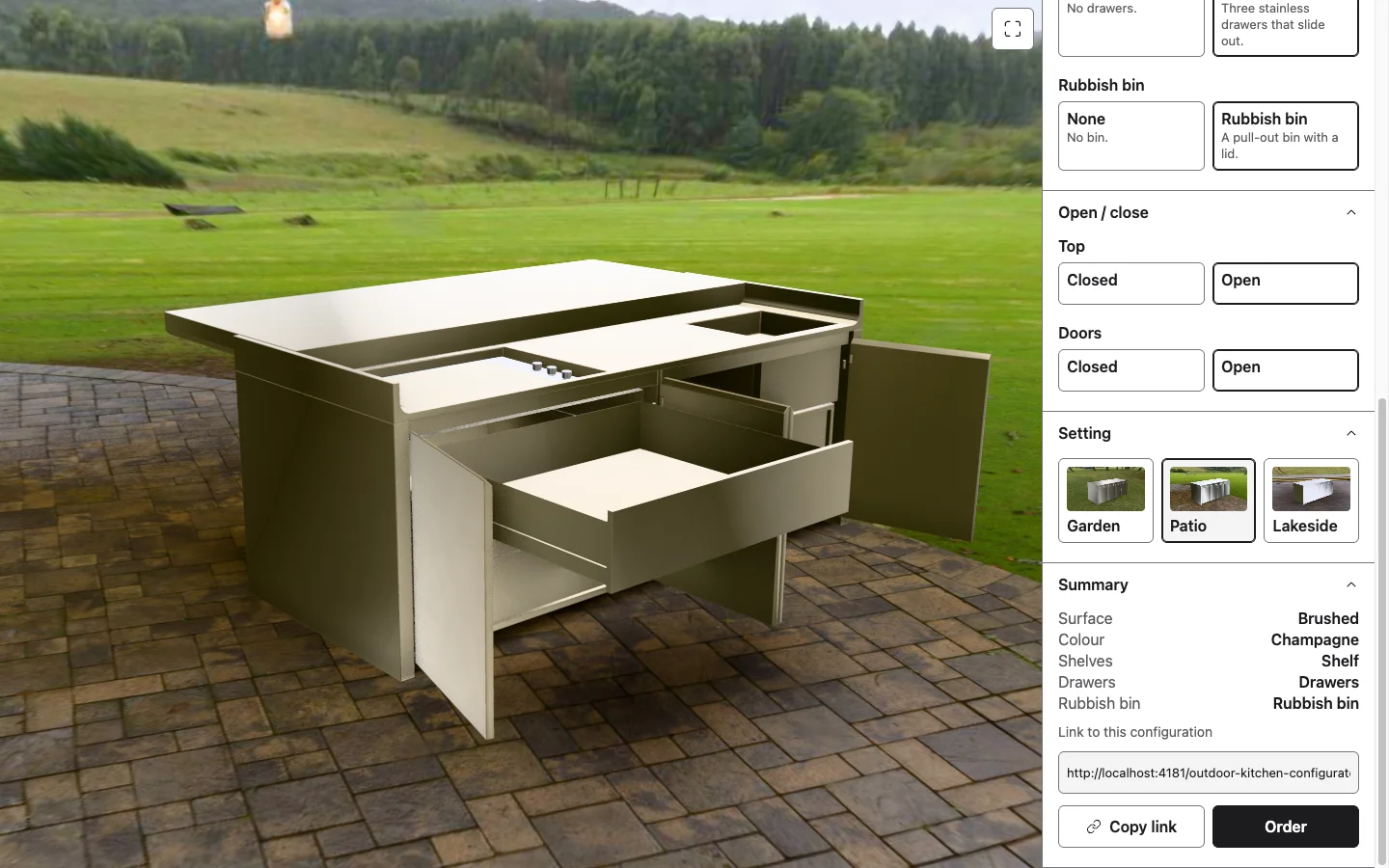 The unit in brushed champagne on a patio with the top slid back, the doors open and the top drawer pulled out, showing the griddle, controls and sink